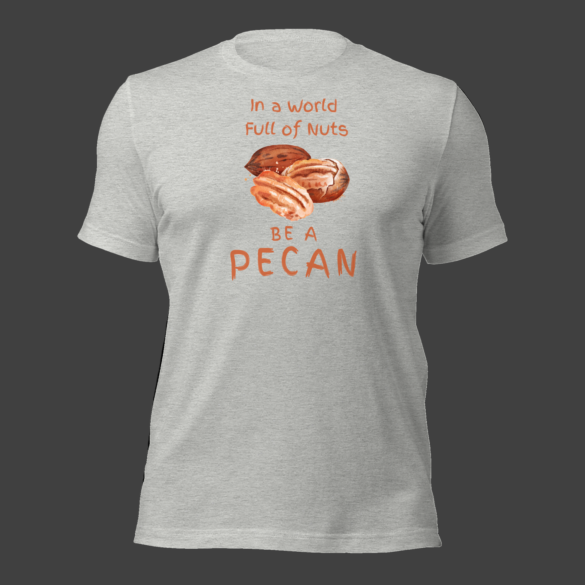 Cartoon-style Pecan Pete on a Bella+Canvas 3001C t-shirt with the slogan “In a world full of nuts, be a pecan.” A playful, humorous design celebrating pecans with a small NuttyMerch logo printed on the back near the neck.