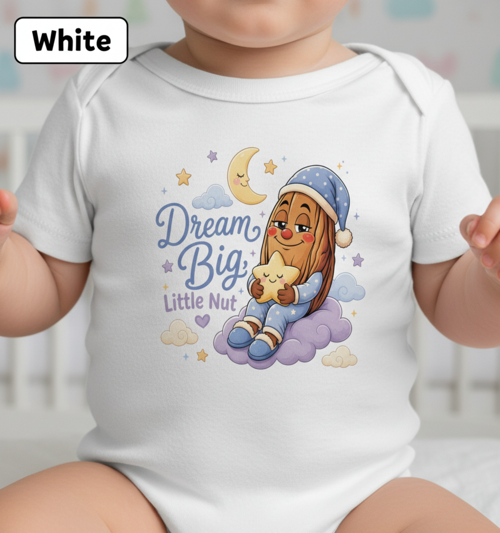 A baby wearing a white short-sleeve bodysuit with a colorful cartoon graphic of a girl in a blue nightcap and pajamas hugging a star on a cloud, with the text 'Dream Big, Little Nut.' A 'White' color label is shown in the top-left corner.