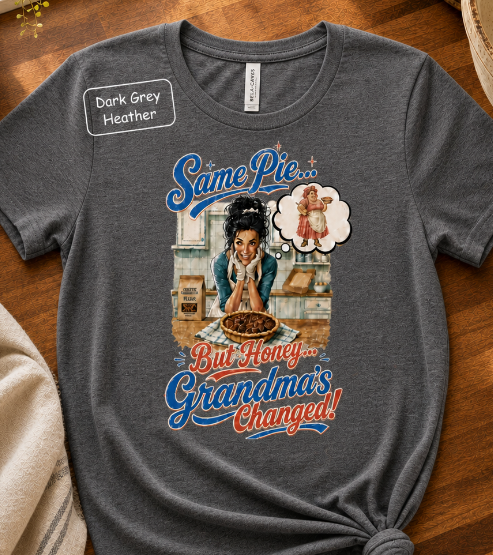 Bella+Canvas t-shirt displaying a graphic of a modern, stylish grandma in a kitchen reflecting on traditional grandmas, with retro typography reading "Same Pie, Grandma's Changed".