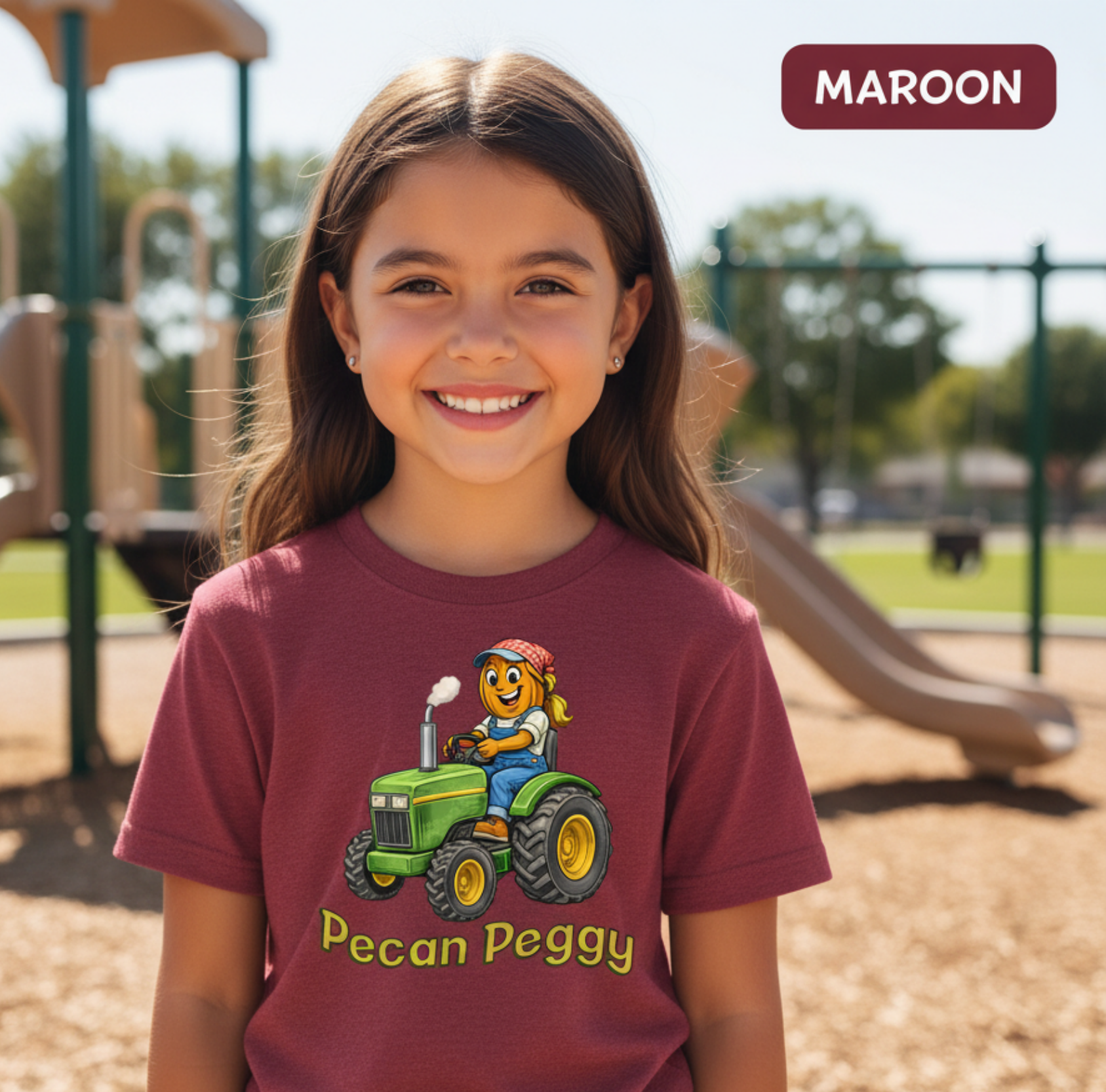 Young girl wearing a maroon t-shirt with a cartoon character on a playground