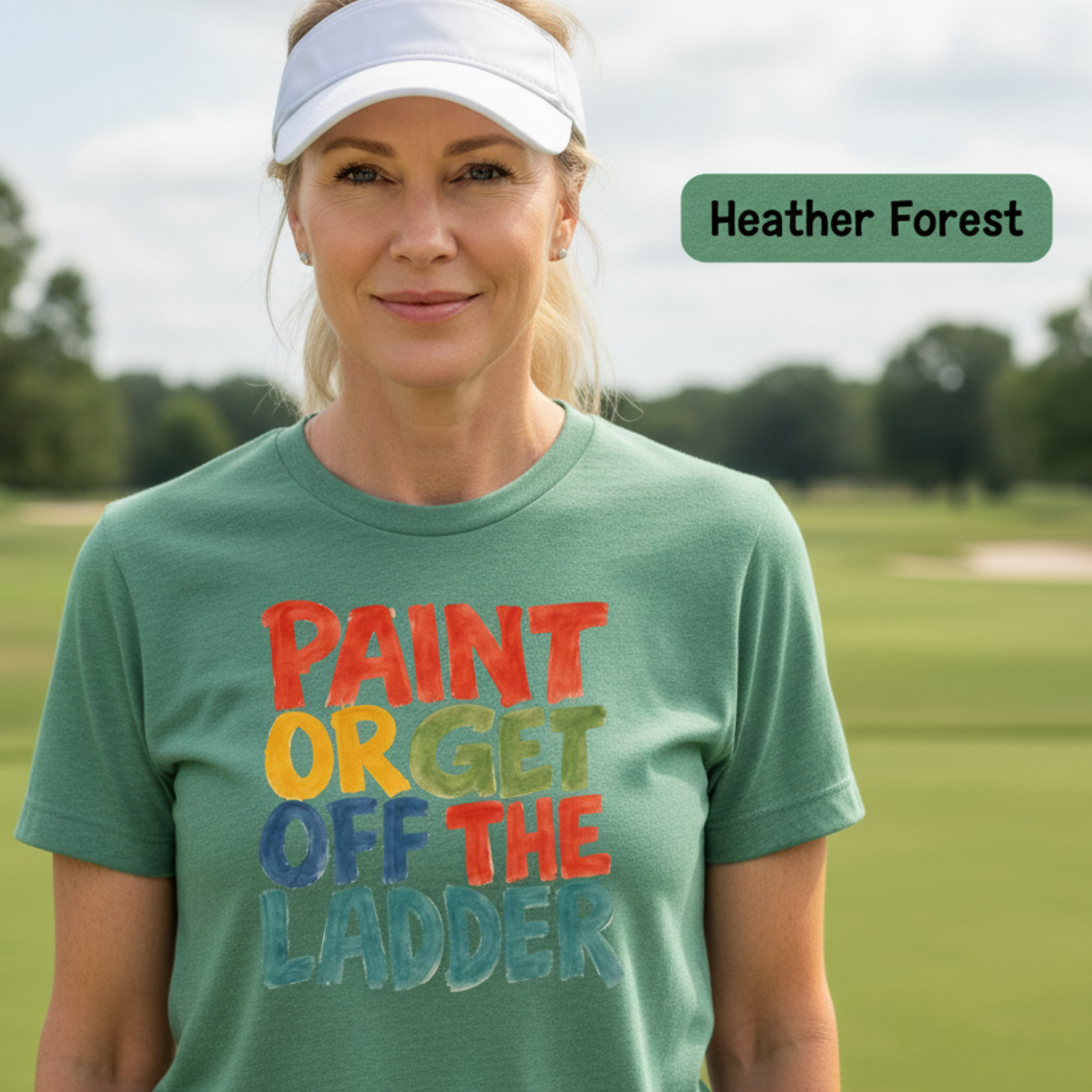 Lady golfer wearing a green t-shirt with colorful text on a golf course, with 'Heather Forest' branding.