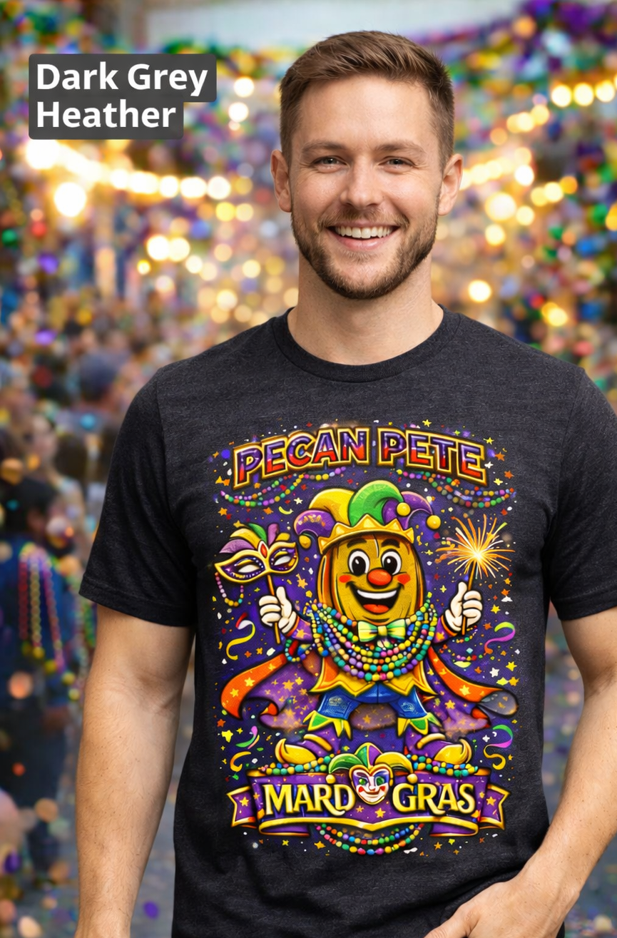 Smiling model wearing a colorful Mardi Gras Pecan Pete graphic T-shirt, featuring a festive jester pecan character with beads, mask, sparkler, and parade confetti, photographed against a lively Mardi Gras celebration background.