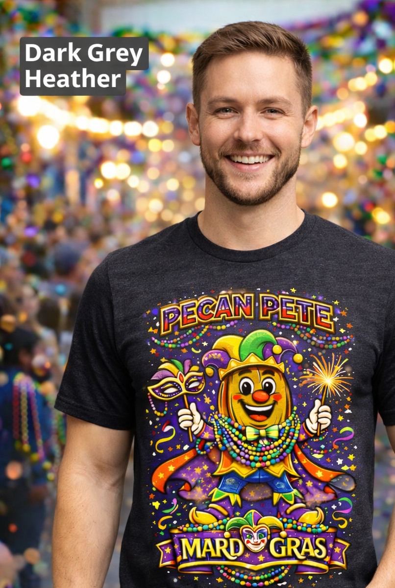 Smiling model wearing a colorful Mardi Gras Pecan Pete graphic T-shirt, featuring a festive jester pecan character with beads, mask, sparkler, and parade confetti, photographed against a lively Mardi Gras celebration background.