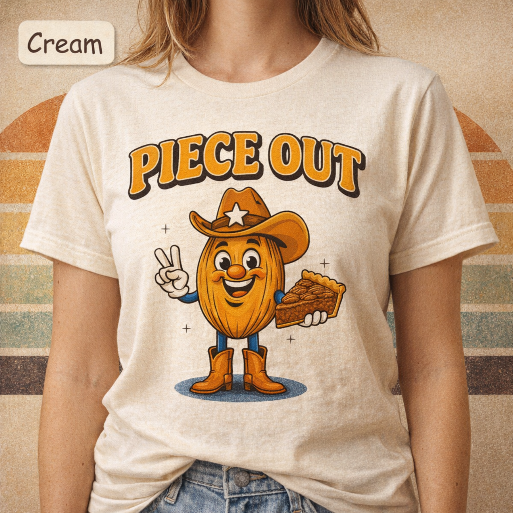 A person wearing a cream-colored graphic t-shirt with a cartoon character and the text 'PIECE OUT'. The image includes a 'Cream' color label overlay in the top left corner.