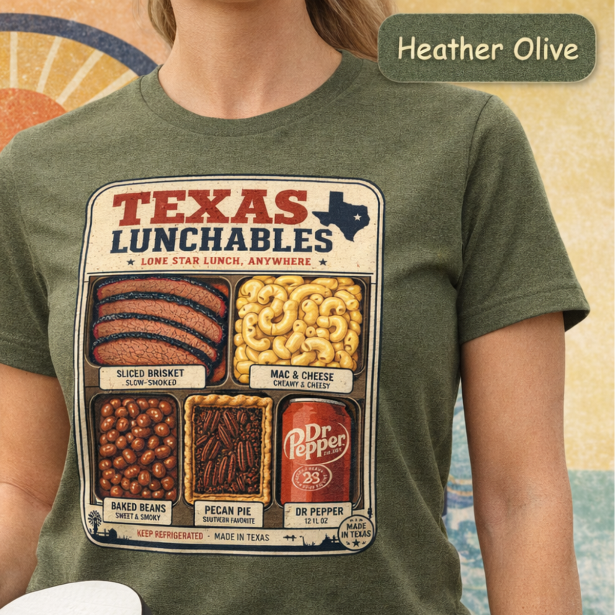 Vintage-style "Texas Lunchables" graphic tee illustrating a classic Texan BBQ meal with brisket, mac and cheese, pecan pie, beans, and a soft drink.