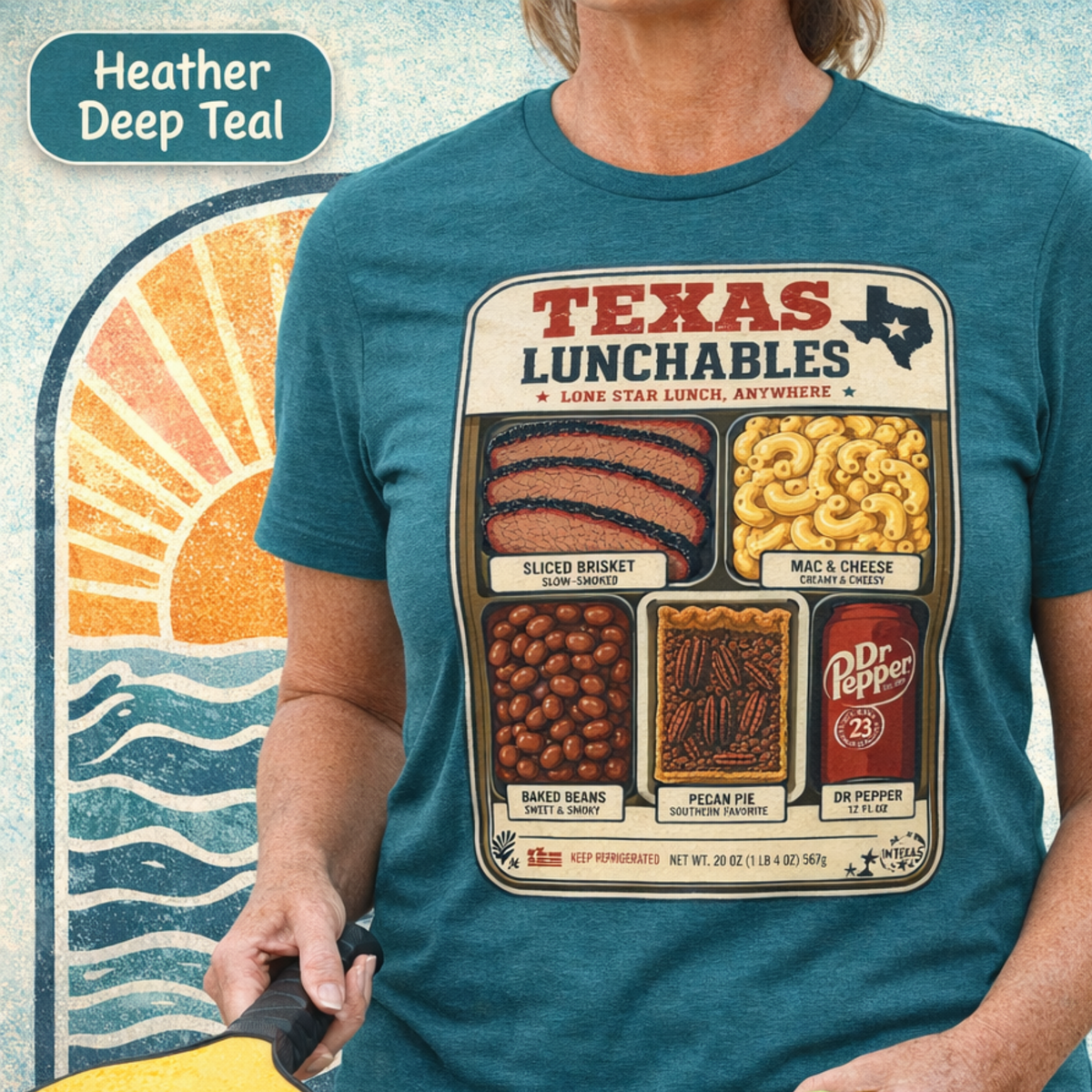 Vintage-style "Texas Lunchables" graphic tee illustrating a classic Texan BBQ meal with brisket, mac and cheese, pecan pie, beans, and a soft drink.