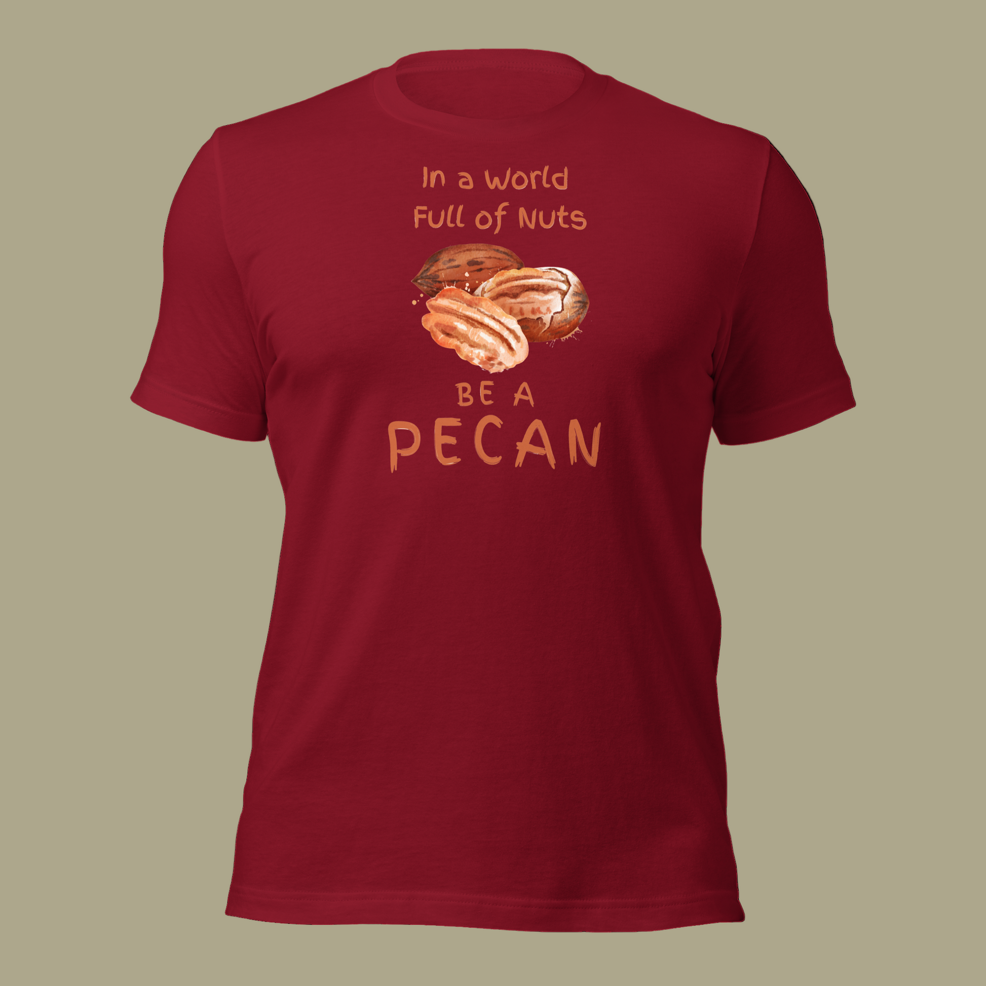 Cartoon-style Pecan Pete on a Bella+Canvas 3001C t-shirt with the slogan “In a world full of nuts, be a pecan.” A playful, humorous design celebrating pecans with a small NuttyMerch logo printed on the back near the neck.