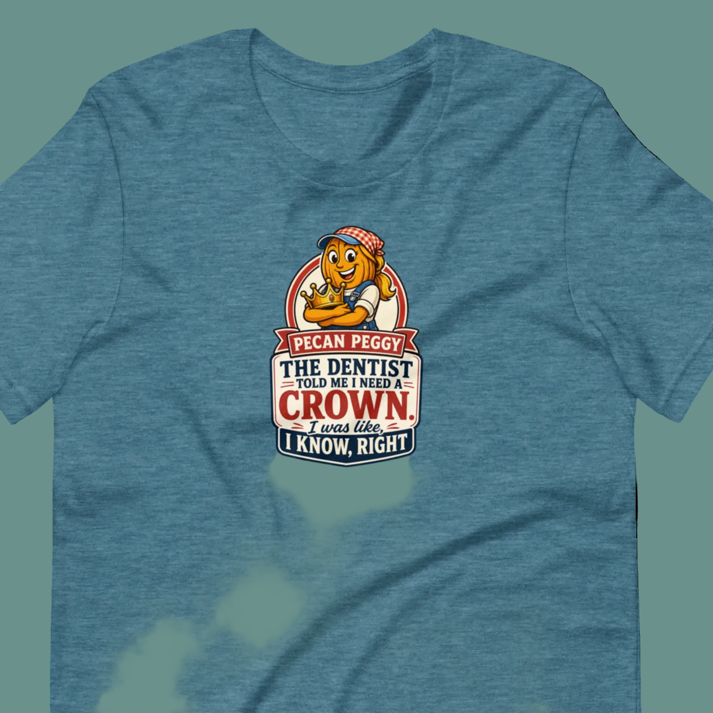 A heather blue short-sleeve t-shirt with a cartoon graphic of a lion wearing a crown and the text 'I CAN PEGGY THE DENTIST AND MY FAMILY CROWN. I KNOW, RIGHT.