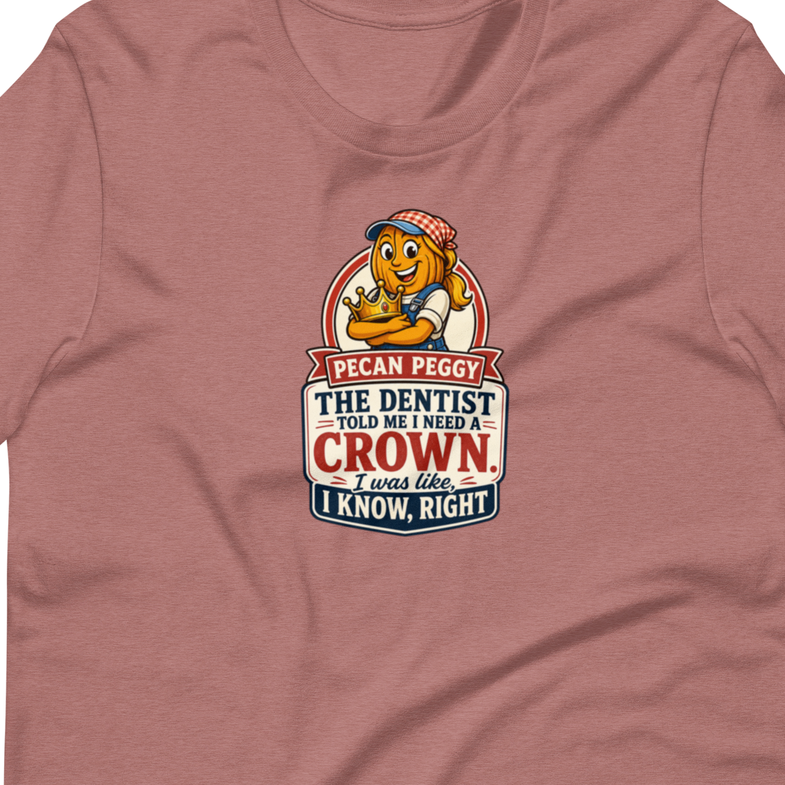 A heathered dusty rose short-sleeve t-shirt with a graphic on the chest featuring a cartoon lion and the text 'I CAN PEGGY THE DENTIST AND MY WHISPER CROWN. I KNOW, RIGHT?'.