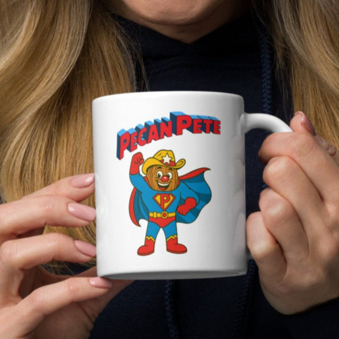 “Super Pecan Pete cartoon superhero with red cape and cowboy hat on white glossy ceramic mug – NuttyMerch Hero Series retro comic design.”